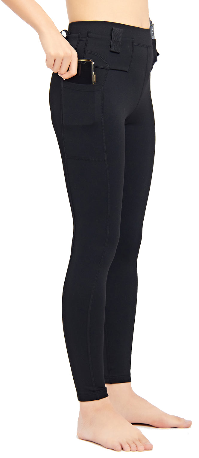 Side view of black concealed carry leggings with a smartphone being lifted from the thigh pocket